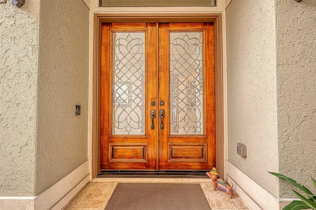 entrance to property featuring french doors and stucco siding