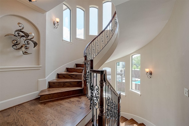 staircase with baseboards and wood finished floors