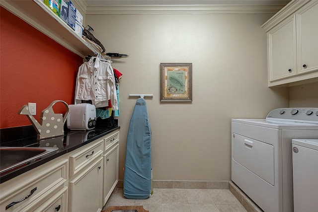 clothes washing area featuring light tile patterned floors, ornamental molding, independent washer and dryer, and cabinet space