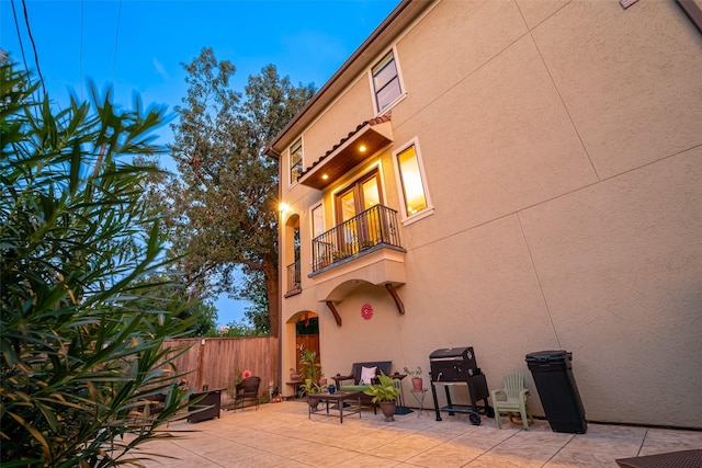 back of house with a patio, fence, a balcony, and stucco siding