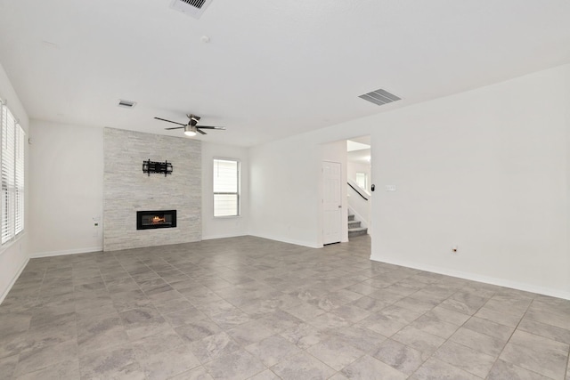 unfurnished living room with visible vents, a fireplace, and stairway