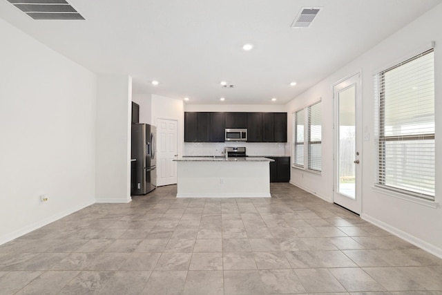 kitchen with baseboards, visible vents, stainless steel appliances, light countertops, and backsplash