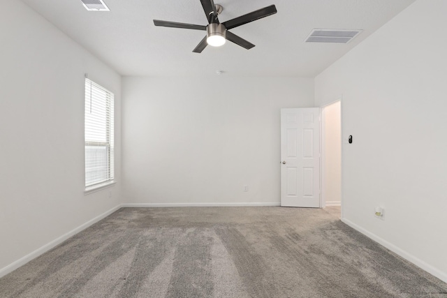 carpeted empty room with visible vents, ceiling fan, and baseboards