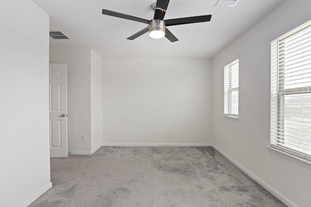 empty room with ceiling fan, carpet, visible vents, and baseboards