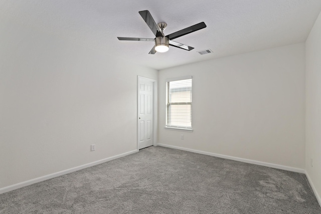 spare room with carpet floors, baseboards, visible vents, and ceiling fan