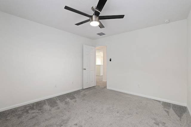 spare room featuring carpet, visible vents, ceiling fan, and baseboards