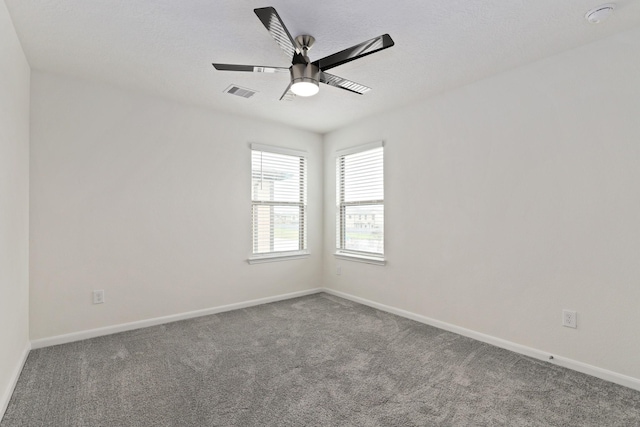 spare room with baseboards, carpet, visible vents, and a ceiling fan