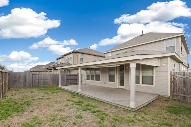 back of house with a fenced backyard, a lawn, and a patio