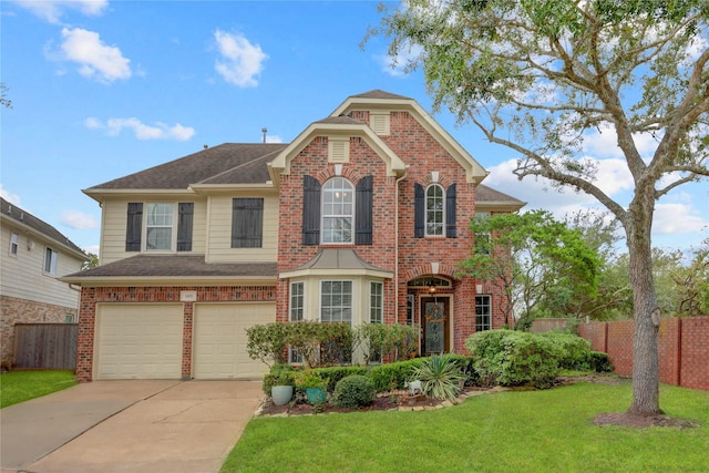 traditional-style house featuring brick siding, an attached garage, a front yard, fence, and driveway