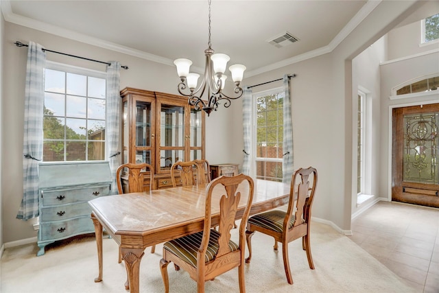 dining area featuring a notable chandelier, baseboards, visible vents, and crown molding