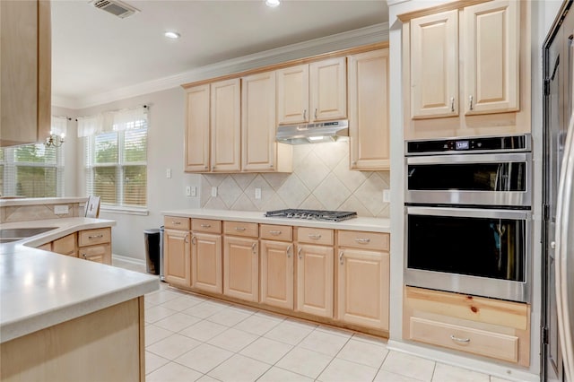 kitchen featuring under cabinet range hood, stainless steel appliances, visible vents, light brown cabinetry, and crown molding