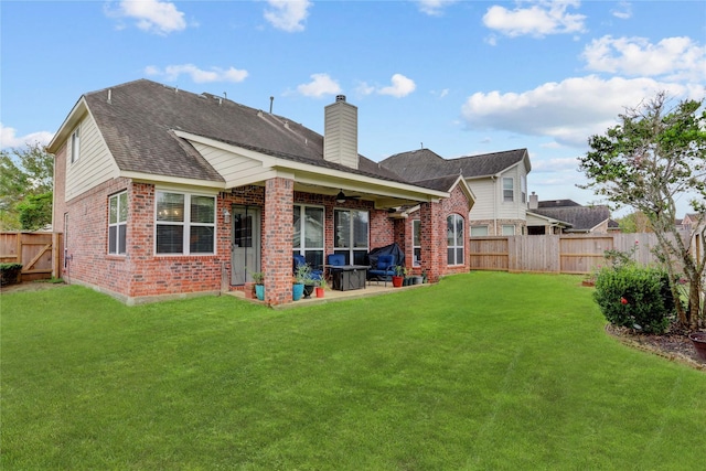 back of property with a yard, a fenced backyard, a patio, and brick siding