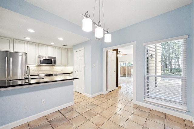 kitchen with light tile patterned floors, decorative backsplash, appliances with stainless steel finishes, white cabinets, and a sink