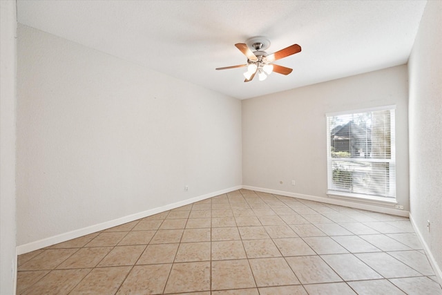 unfurnished room with a ceiling fan, baseboards, and light tile patterned floors