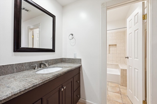 bathroom with visible vents, vanity,  shower combination, tile patterned flooring, and baseboards