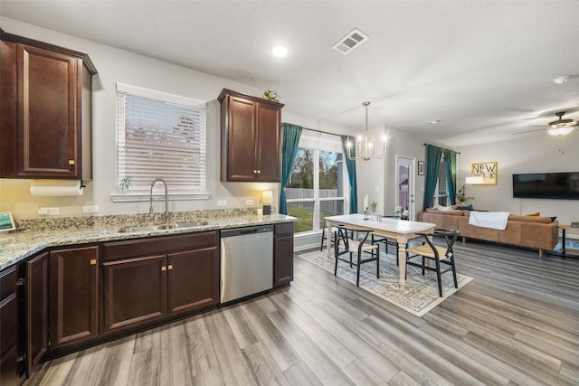 kitchen with light stone counters, dishwasher, light wood-type flooring, and a sink