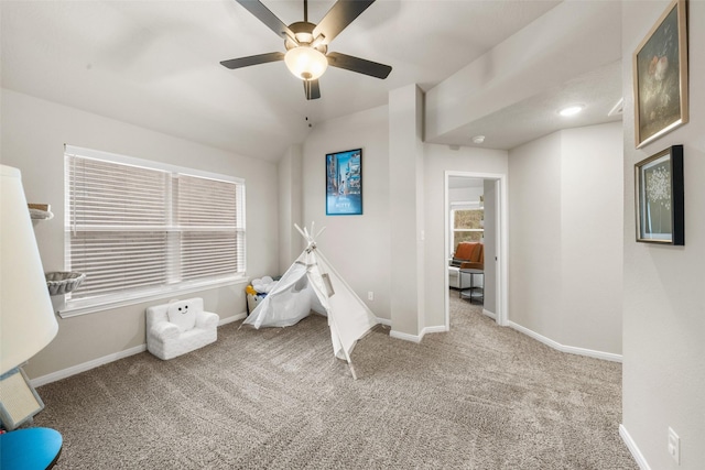 recreation room with baseboards, lofted ceiling, ceiling fan, and carpet flooring