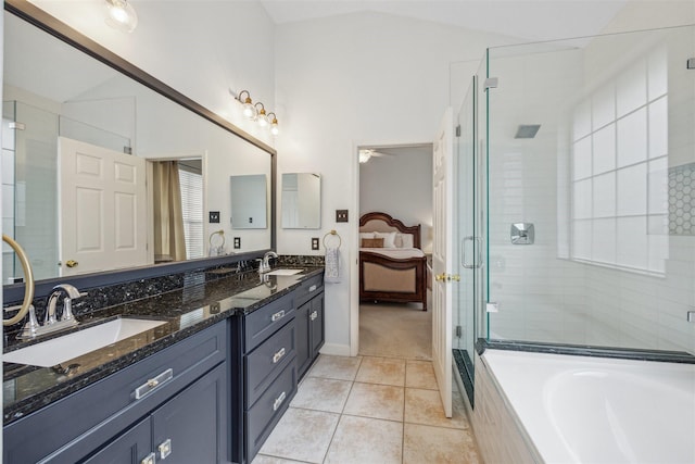 ensuite bathroom with tile patterned floors, vaulted ceiling, connected bathroom, and a sink