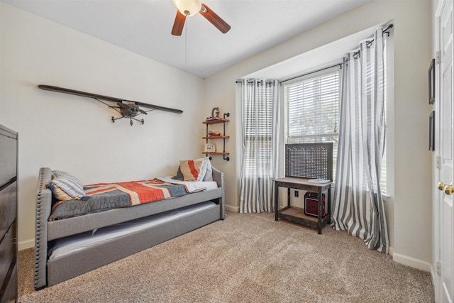 carpeted bedroom featuring baseboards and a ceiling fan