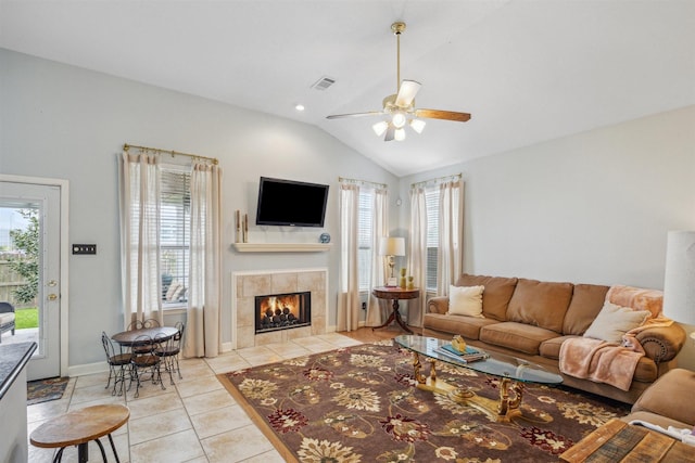 living area featuring a wealth of natural light, visible vents, light tile patterned floors, and vaulted ceiling