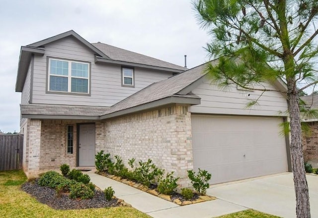 traditional home with a garage, driveway, brick siding, and fence