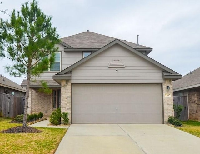 traditional-style home with a garage, concrete driveway, brick siding, and fence