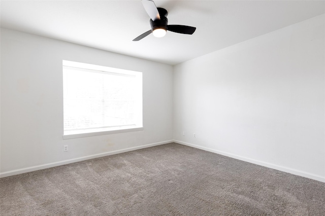 carpeted empty room with a ceiling fan and baseboards