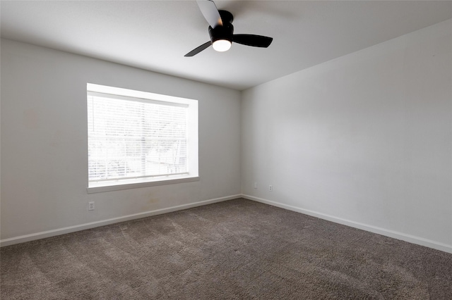 carpeted empty room with ceiling fan and baseboards