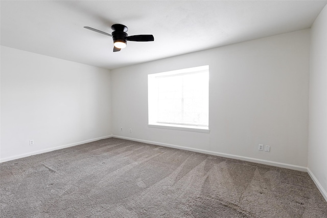 carpeted empty room with ceiling fan and baseboards