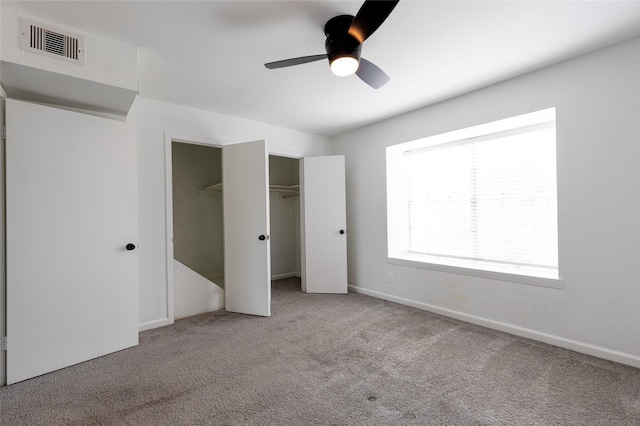 unfurnished bedroom featuring carpet floors, a ceiling fan, visible vents, and baseboards