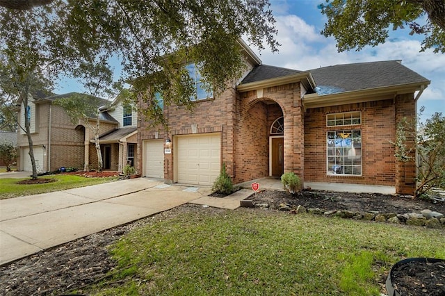 traditional-style home featuring driveway, a shingled roof, an attached garage, a front lawn, and brick siding