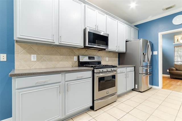 kitchen with visible vents, appliances with stainless steel finishes, tasteful backsplash, dark countertops, and crown molding