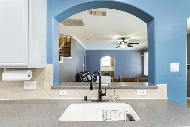 kitchen featuring visible vents, arched walkways, and a sink