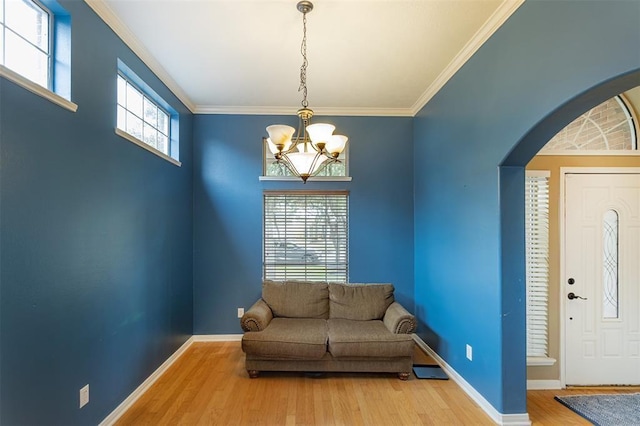 sitting room with baseboards, wood finished floors, and ornamental molding