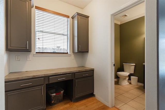 bathroom with toilet, visible vents, vanity, baseboards, and ornamental molding