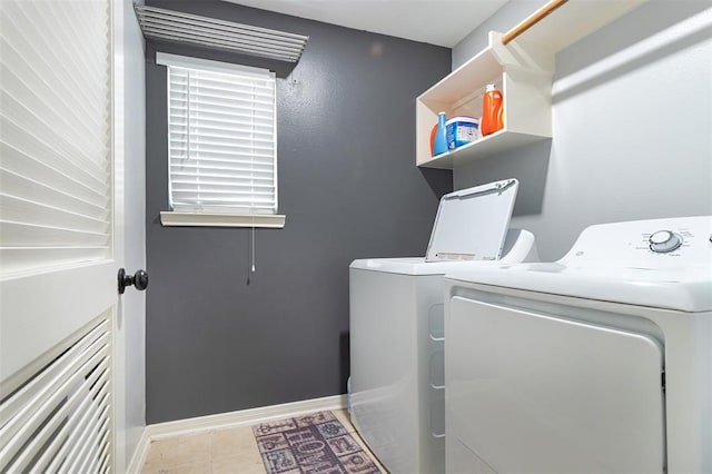 laundry room featuring laundry area, separate washer and dryer, tile patterned floors, and baseboards