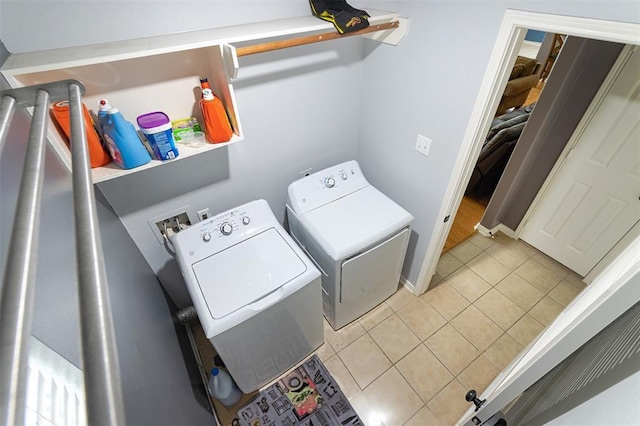 laundry room with washer and clothes dryer and light tile patterned flooring