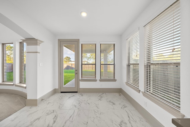 entryway with baseboards, marble finish floor, and a healthy amount of sunlight