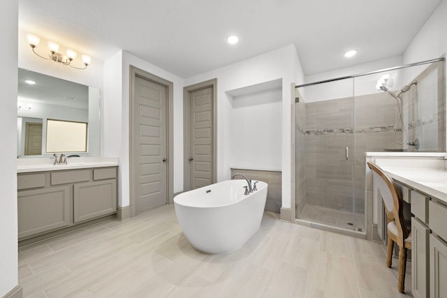 bathroom with a freestanding tub, two vanities, a sink, and a shower stall