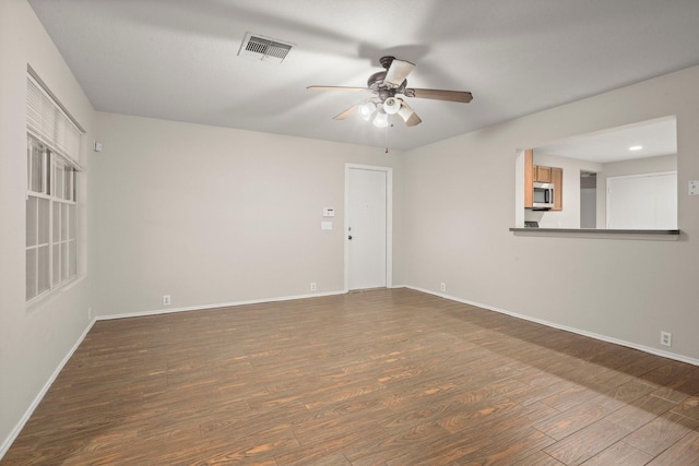 empty room featuring baseboards, visible vents, and wood finished floors