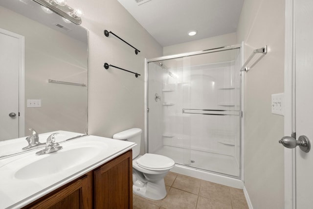 bathroom with toilet, a shower stall, vanity, and tile patterned floors