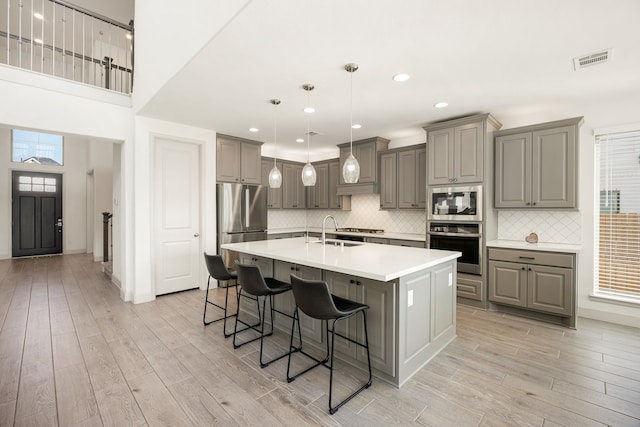 kitchen with light wood-style floors, gray cabinets, and visible vents