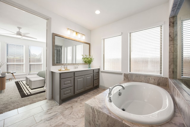 full bath featuring a washtub, a healthy amount of sunlight, and vanity