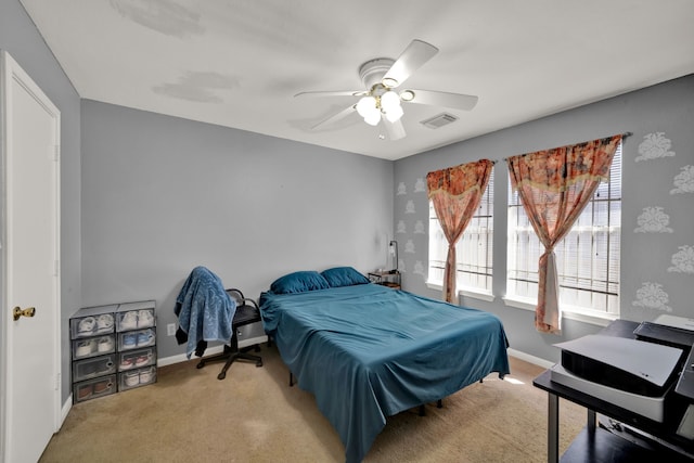 carpeted bedroom featuring ceiling fan, visible vents, and baseboards