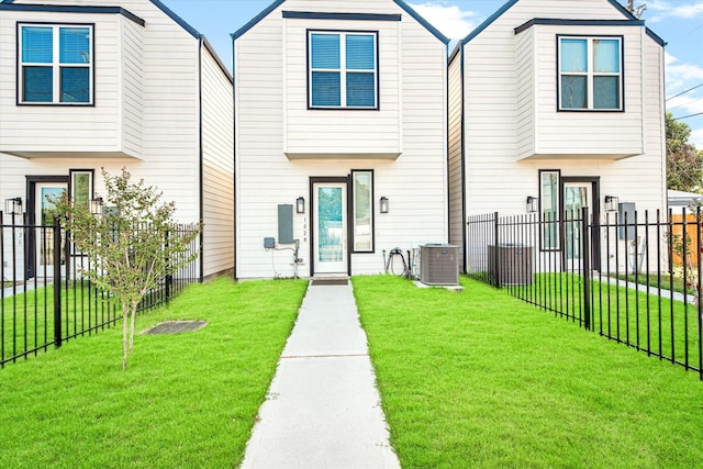 view of front of home featuring a front yard, fence, and central air condition unit