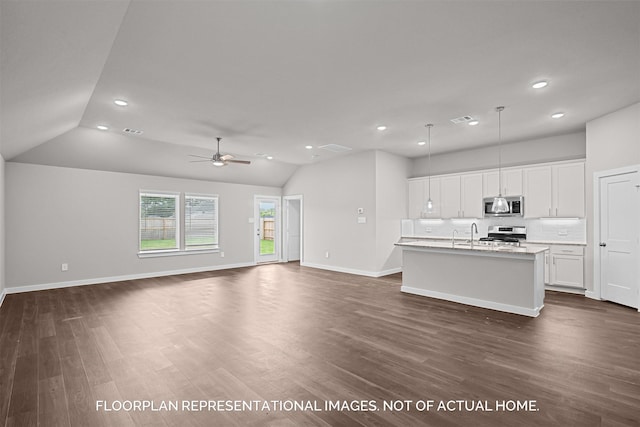 kitchen with stainless steel microwave, visible vents, a kitchen island with sink, white cabinetry, and range