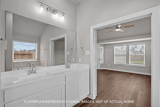 bathroom featuring ceiling fan, lofted ceiling, a sink, and wood finished floors