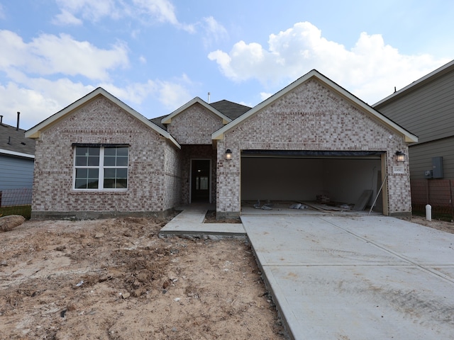 ranch-style house featuring concrete driveway, brick siding, and a garage