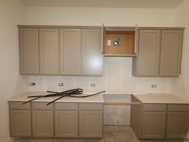 kitchen featuring light countertops, open shelves, and gray cabinetry