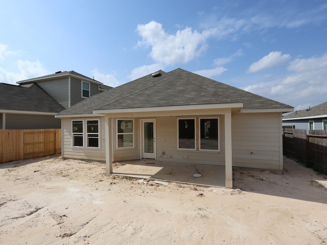 back of property featuring a patio area, roof with shingles, and a fenced backyard